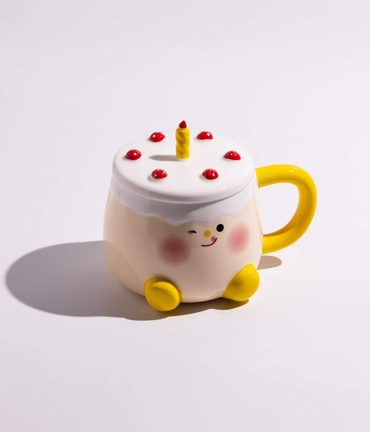 كوب سيراميك بتصميم قالب كيك على الغطاء وشمعة في الوسط