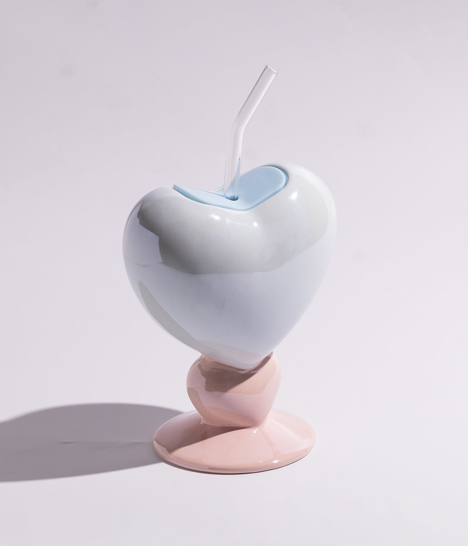 Vibrant heart-shaped ceramic mug with a straw for easy drinking