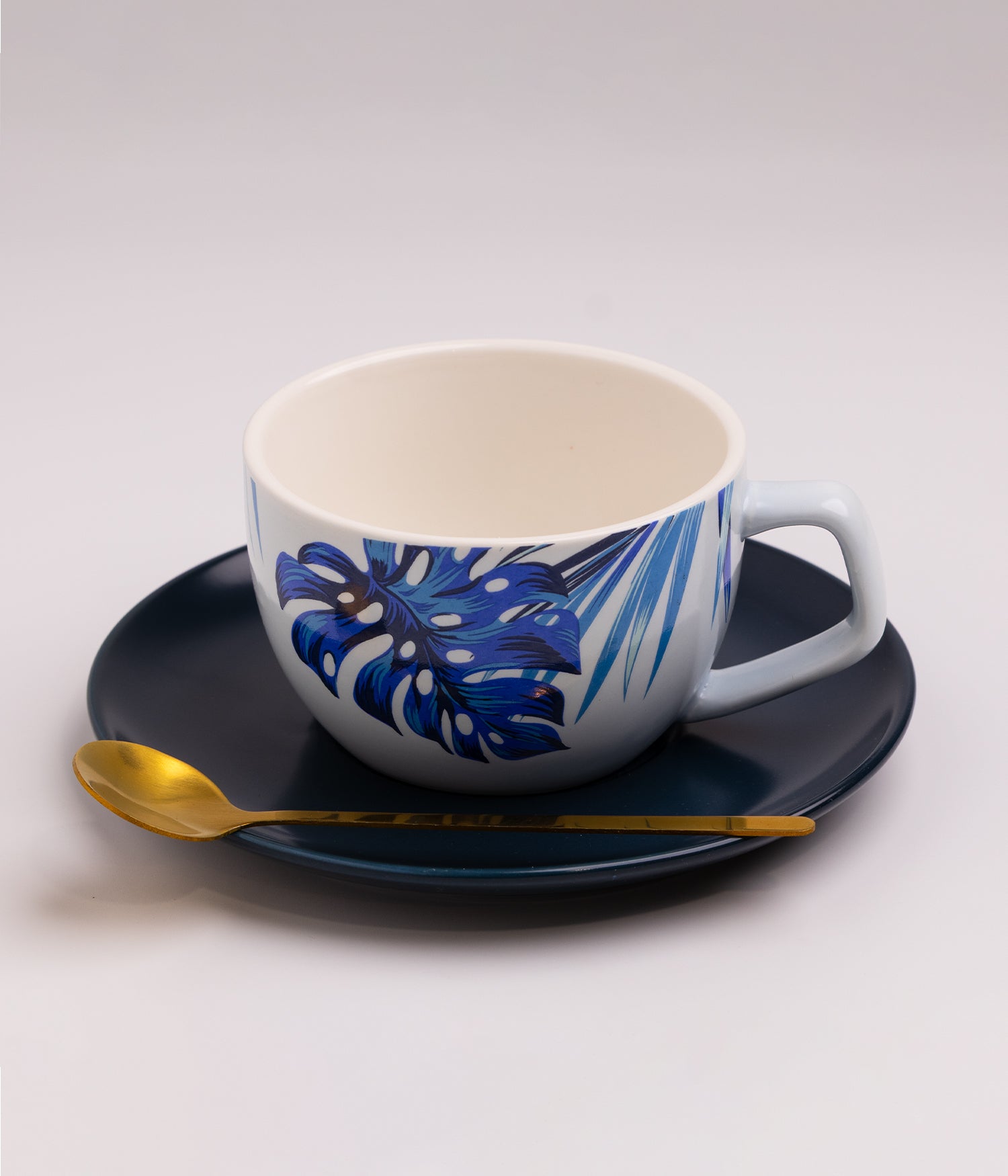 فنجان قهوة سيراميك بنقوش فنية زرقاء مع صحن أسود وملعقة