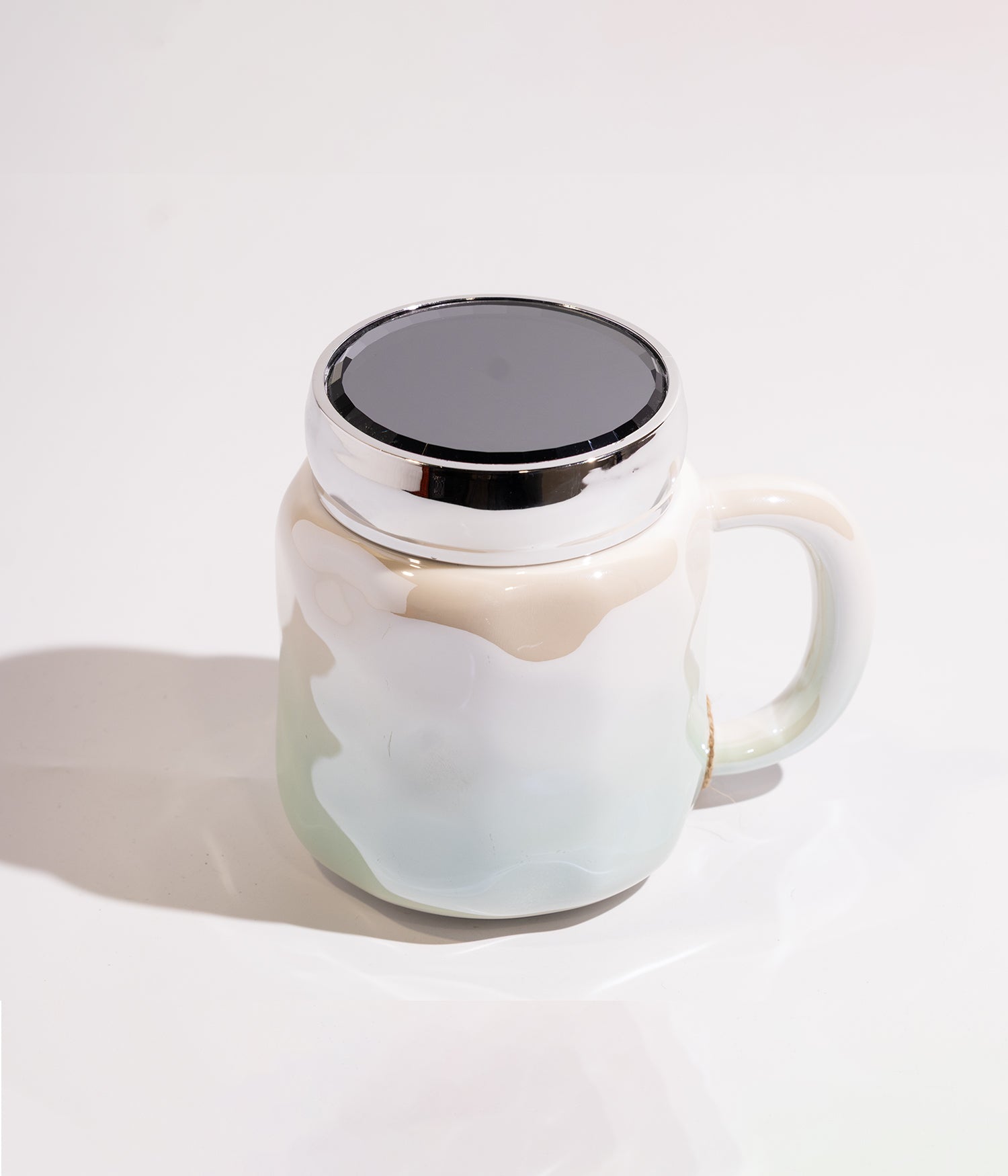 كوب سيراميك بتصميم هندسي مموج مع تدرج لوني فاتح، وغطاء محكم الإغلاق لحفظ الحرارة باللون الأزرق المخضر