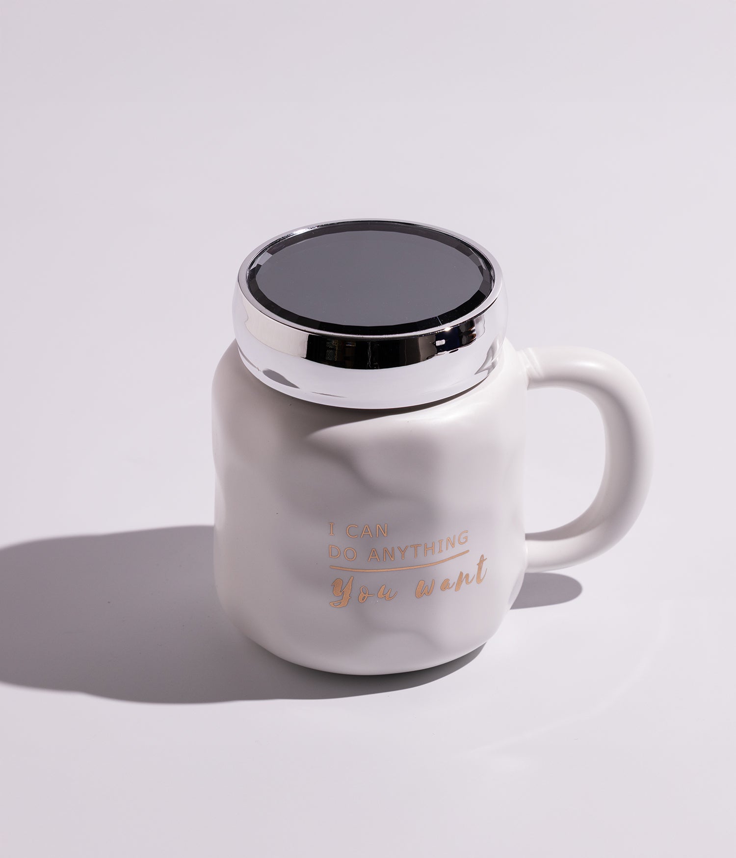 كوب سيراميك مزين بعبارات معبرة بتصميم أنيق، مع غطاء فضي محكم الإغلاق لحفظ الحرارة، باللون الأبيض