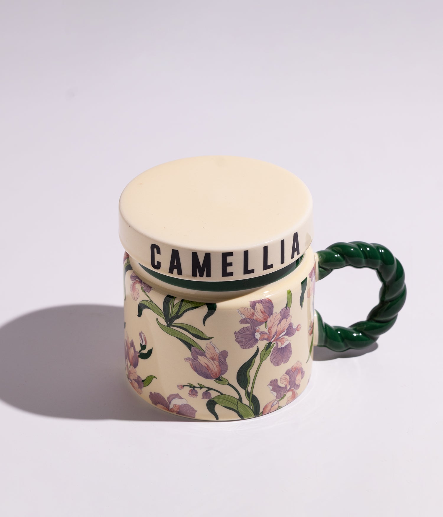 كوب مصنوع من السيراميك مزين بورود ملونة مع مقبض أخضر وغطاء محكم الإغلاق، مناسب للاستخدام اليومي مع القهوة أو الشاي