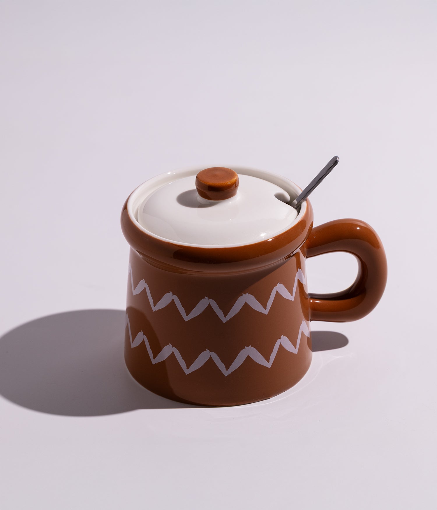 كوب سيراميكي مزين بتصميم يشبه قدور الطهي، يأتي مع غطاء وملعقة، ملائم للاستخدام اليومي في المنزل أو المكتب