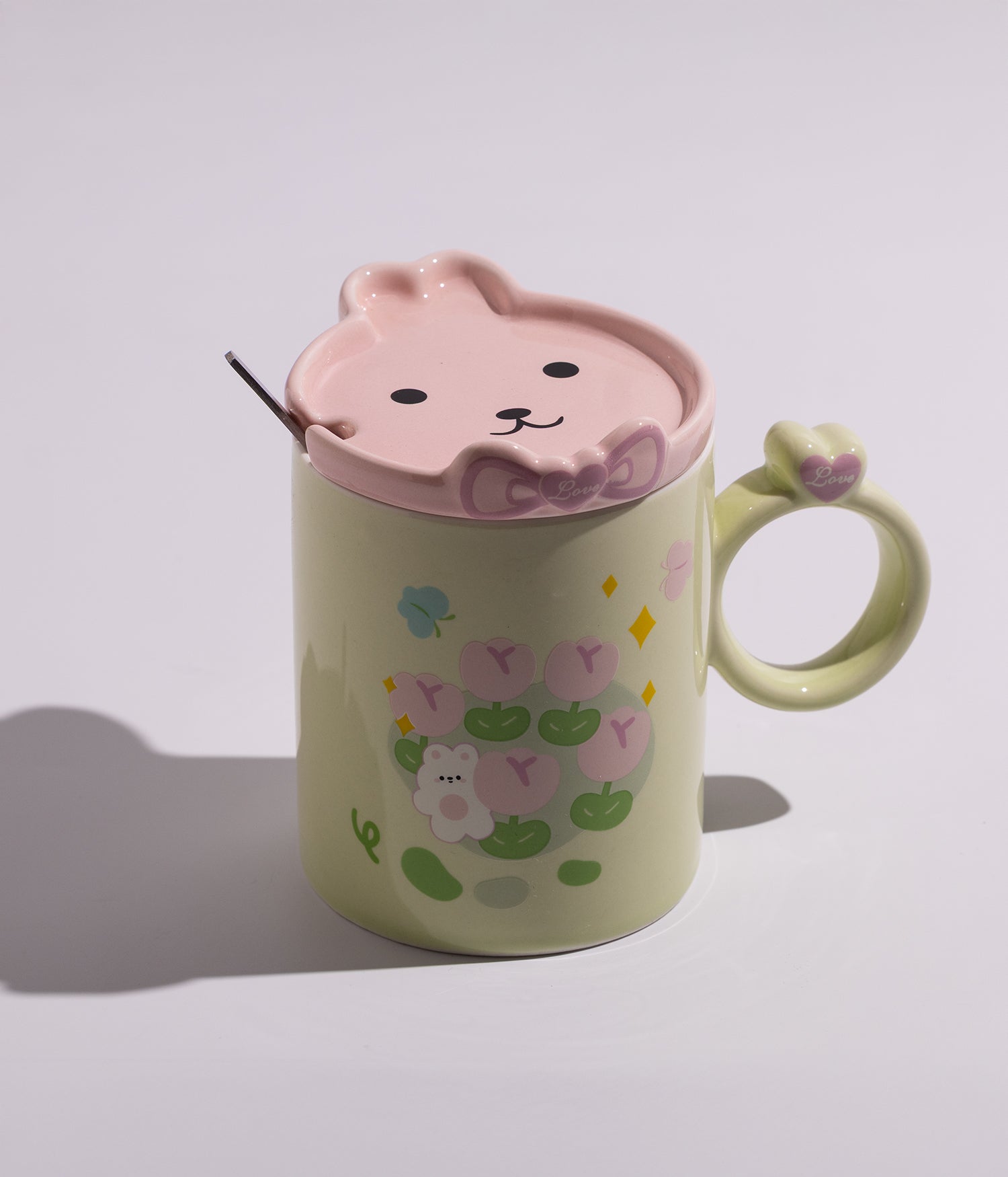 كوب سيراميكي مزين برسومات أرانب ودببة لطيفة في الحقل، مزود بغطاء على شكل أرنوب وملعقة متناسقة، مثالي للأطفال ولإضافة لمسة مرحة على القهوة أو الشاي