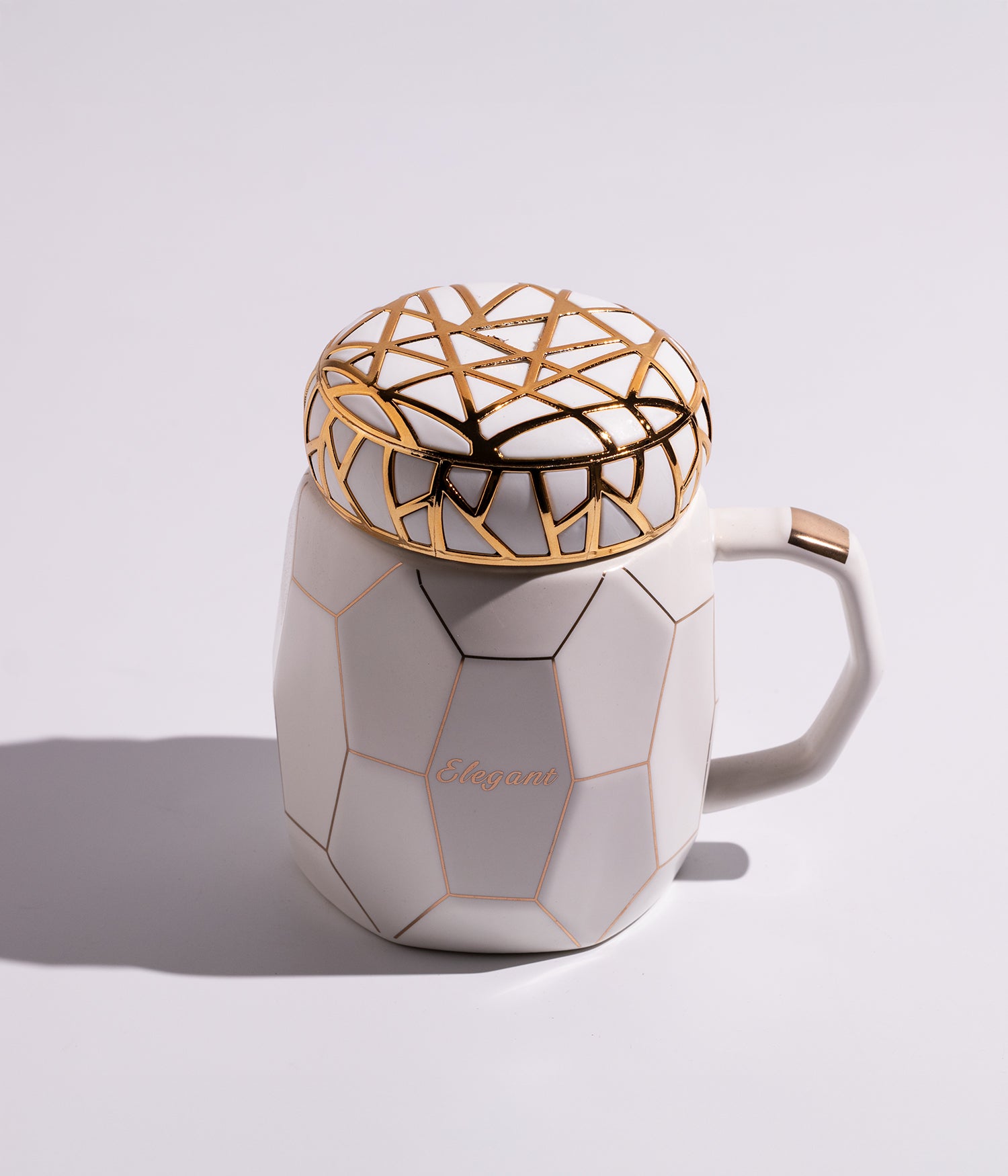 كوب من السيراميك الأبيض مزين بخطوط ذهبية أنيقة على الغطاء، ملائم للاستخدام اليومي مع القهوة أو الشاي