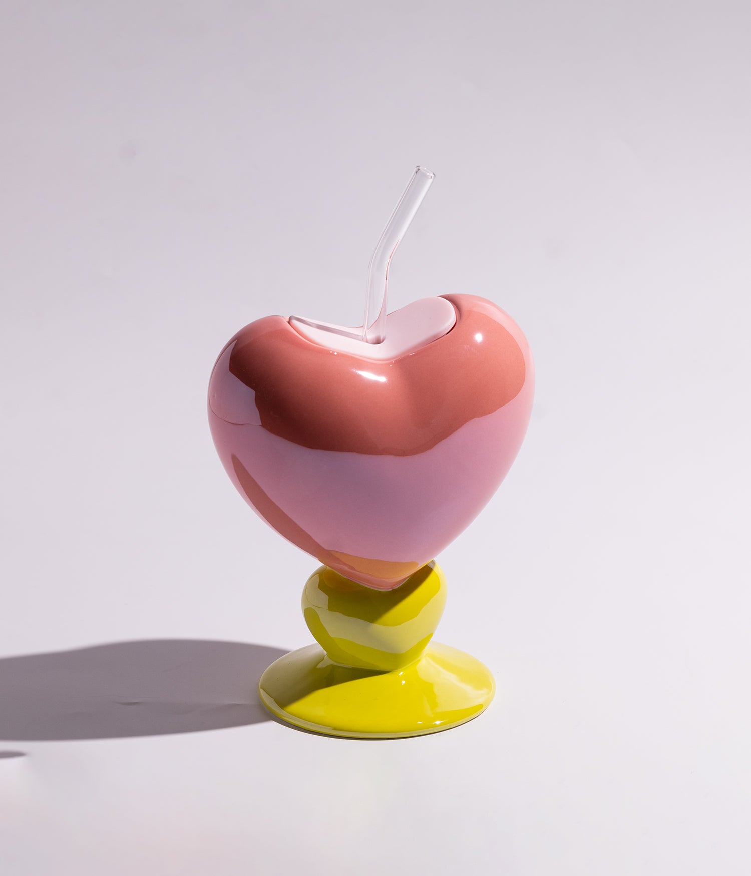 Vibrant heart-shaped ceramic mug with a straw for easy drinking