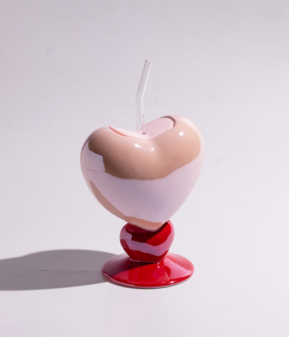 Vibrant heart-shaped ceramic mug with a straw for easy drinking