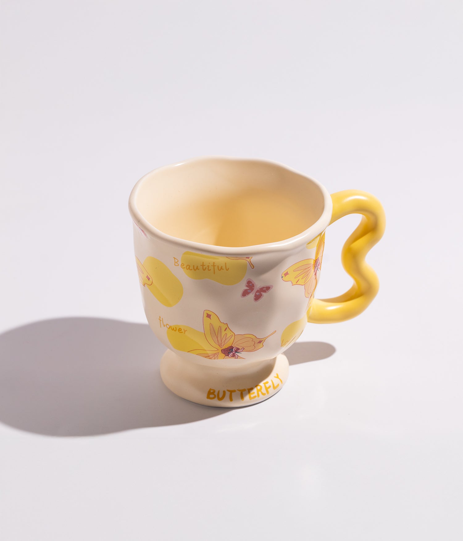 فنجان قهوة بمقبض مموج فريد وبفراشات ملونة