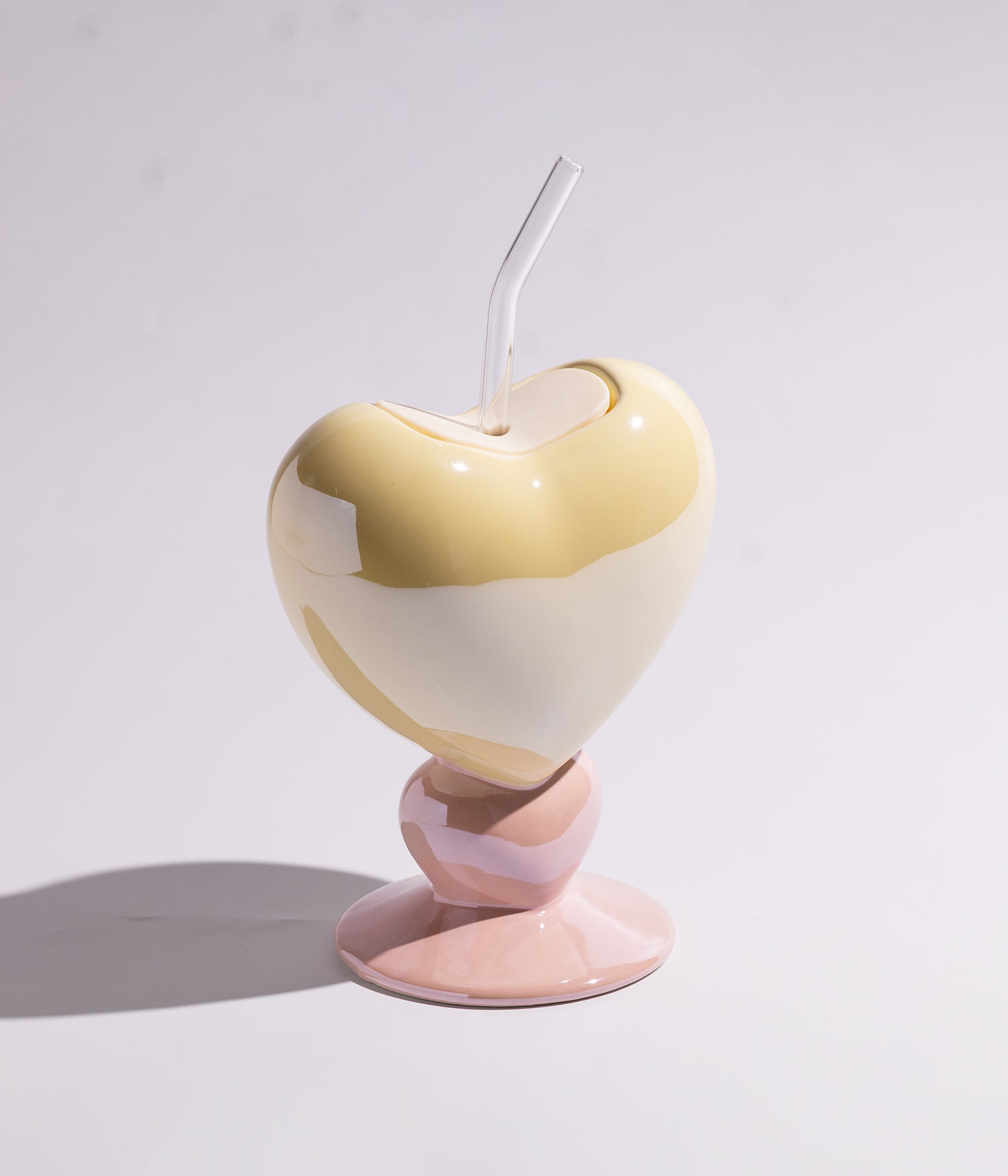 Vibrant heart-shaped ceramic mug with a straw for easy drinking