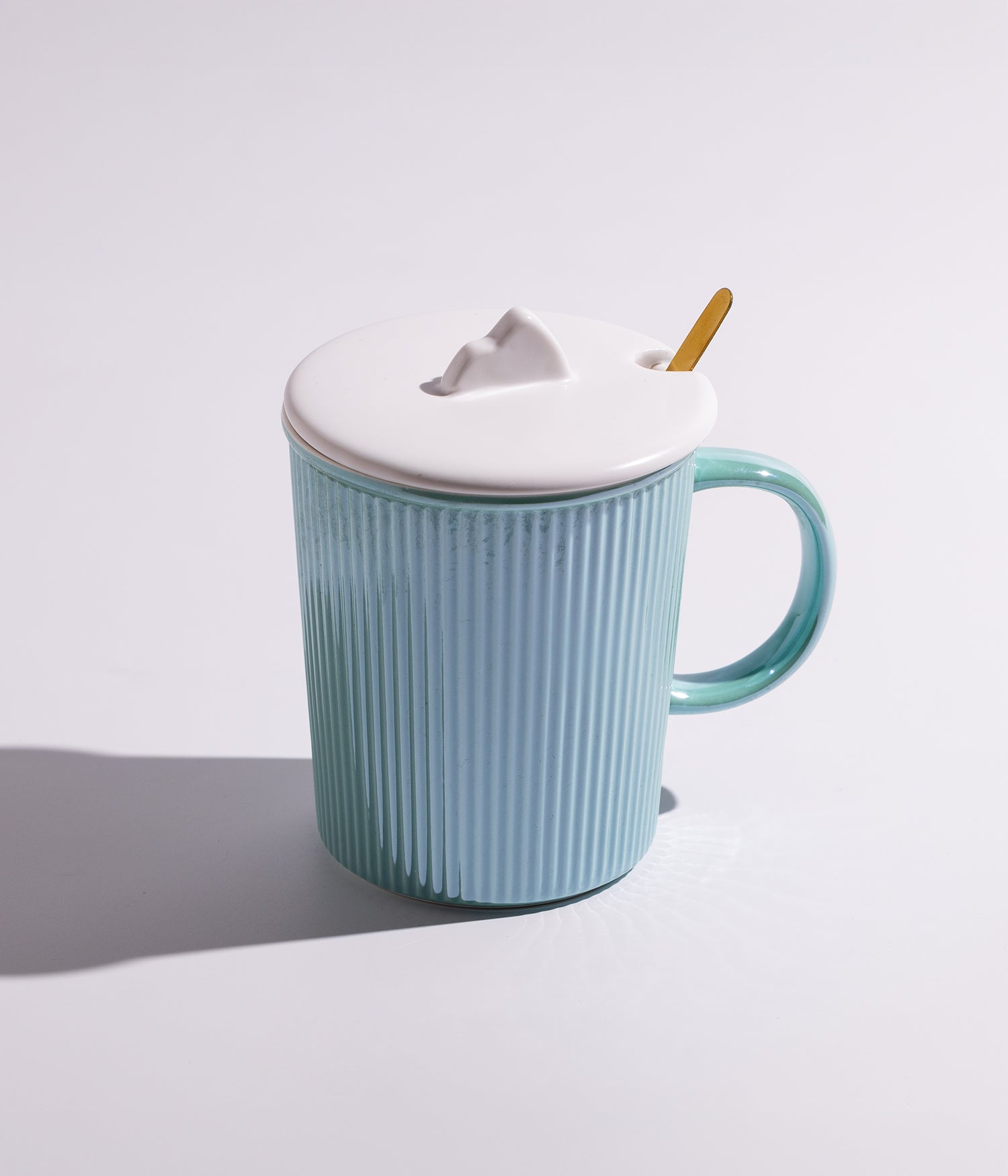 كوب سيراميك مخطط بغطاء أبيض مع معلقة ذهبية