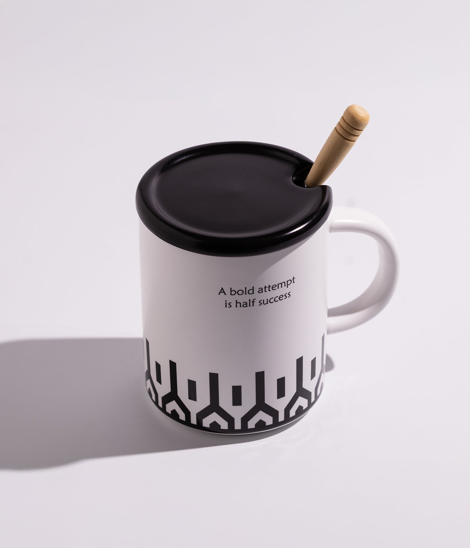 كوب سيراميك بخطوط سوداء مع غطاء وملعقة خشبية