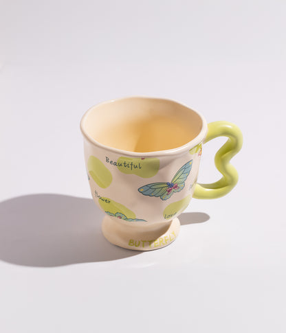 فنجان قهوة بمقبض مموج فريد وبفراشات ملونة