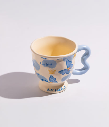 فنجان قهوة بمقبض مموج فريد وبفراشات ملونة