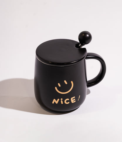 كوب مصنوع من السيراميك بتصميم وجه مبتسم مع كلمة NICE، يأتي باللون الأسود ومزود بغطاء لحفظ الحرارة وملعقة، مناسب للاستخدام اليومي مع المشروبات الساخنة