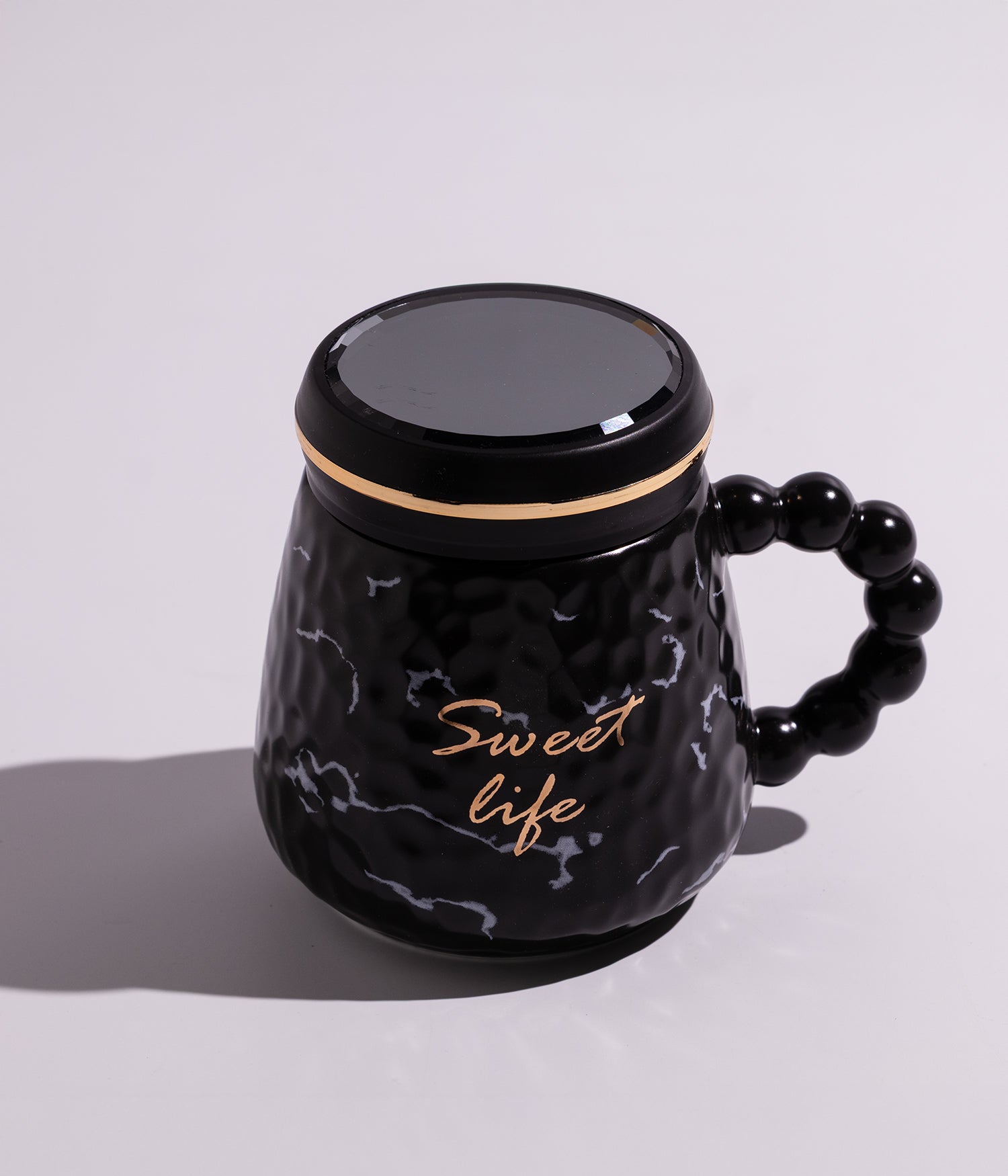 كوب سيراميكي باللون الأسود مزين بخطوط ملونة أنيقة وعبارة "Sweet Life"، مزود بغطاء محكم الإغلاق، مناسب للاستخدام اليومي مع القهوة أو الشاي