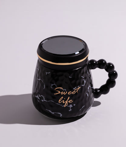 كوب سيراميكي باللون الأسود مزين بخطوط ملونة أنيقة وعبارة "Sweet Life"، مزود بغطاء محكم الإغلاق، مناسب للاستخدام اليومي مع القهوة أو الشاي