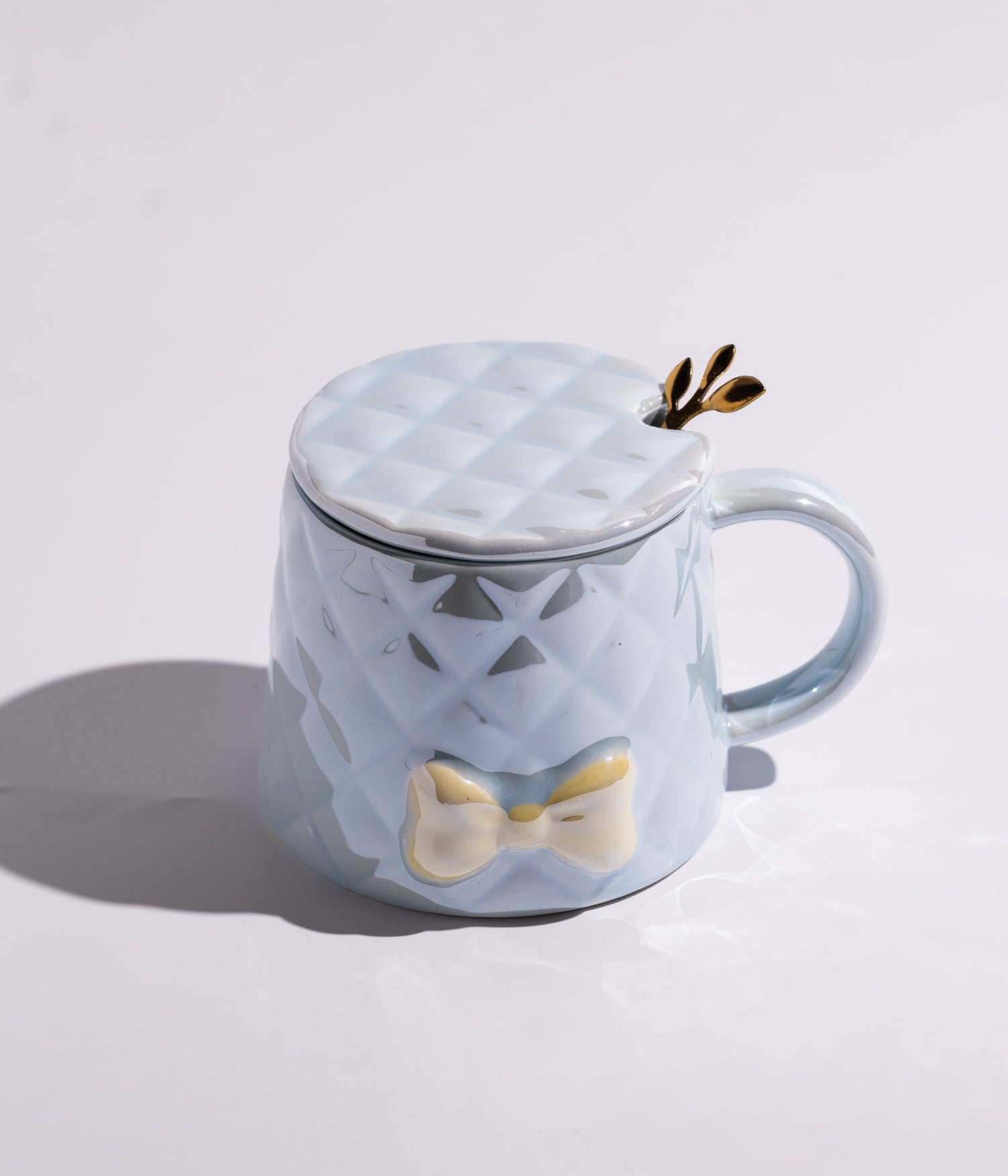 كوب مصنوع من السيراميك بتصميم كاروهات مع بابيون باللون الأزرق، مزود بغطاء وملعقة على شكل سنبلة، مناسب للاستخدام اليومي مع القهوة أو الشاي
