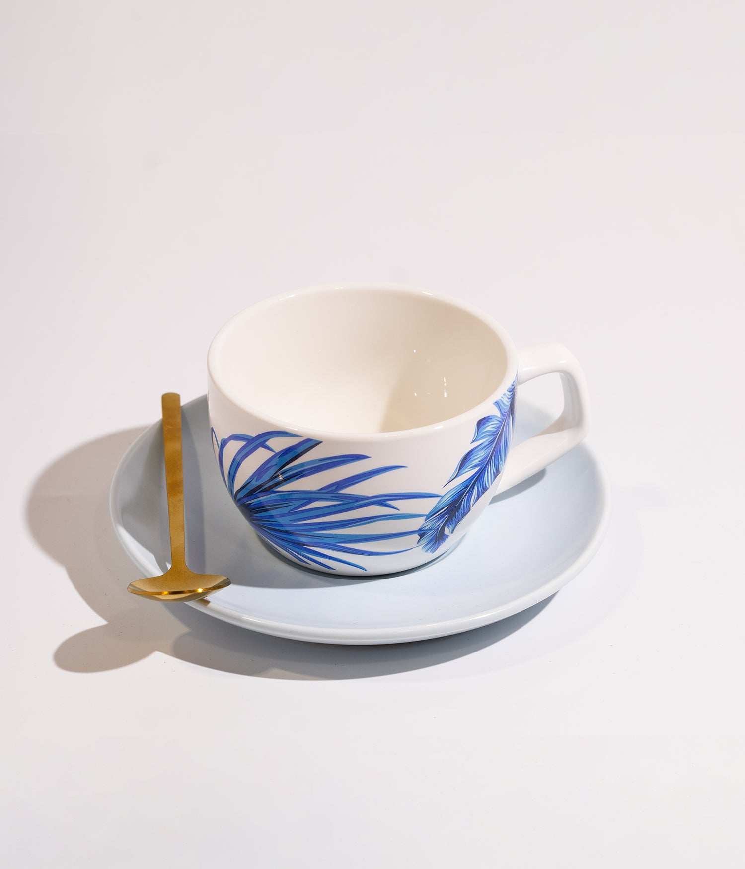 فنجان قهوة سيراميك بنقوش فنية زرقاء مع صحن أبيض وملعقة