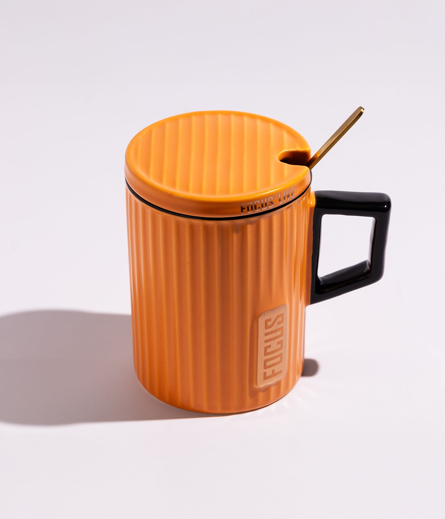 كوب قهوة سيراميك بتصميم هندسي مع مقبض ملون وغطاء وملعقة بعبارة «FOCUS» باللون البرتقالي