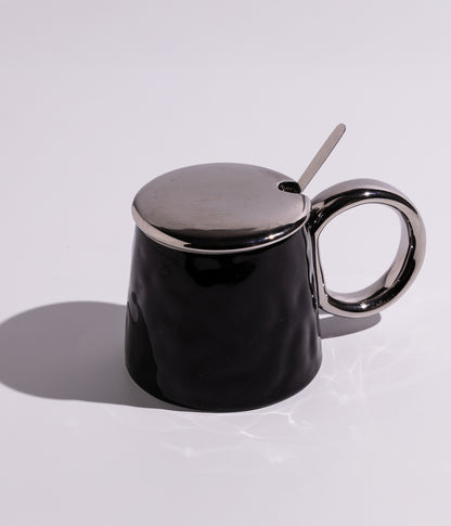 كوب سيراميك بتصميم أنيق مع غطاء ومقبض ميتاليك، مرفق بملعقة معدنية ملونة، باللون الأسود مع غطاء فضي