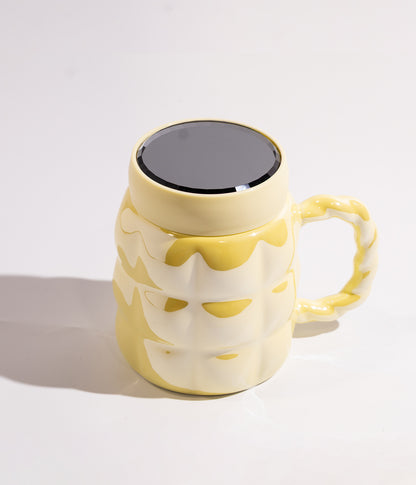 كوب سيراميك بتصميم هندسي وبألوان فاتحة مع غطاء محكم لحفظ الحرارة باللون الأصفر الفاتح