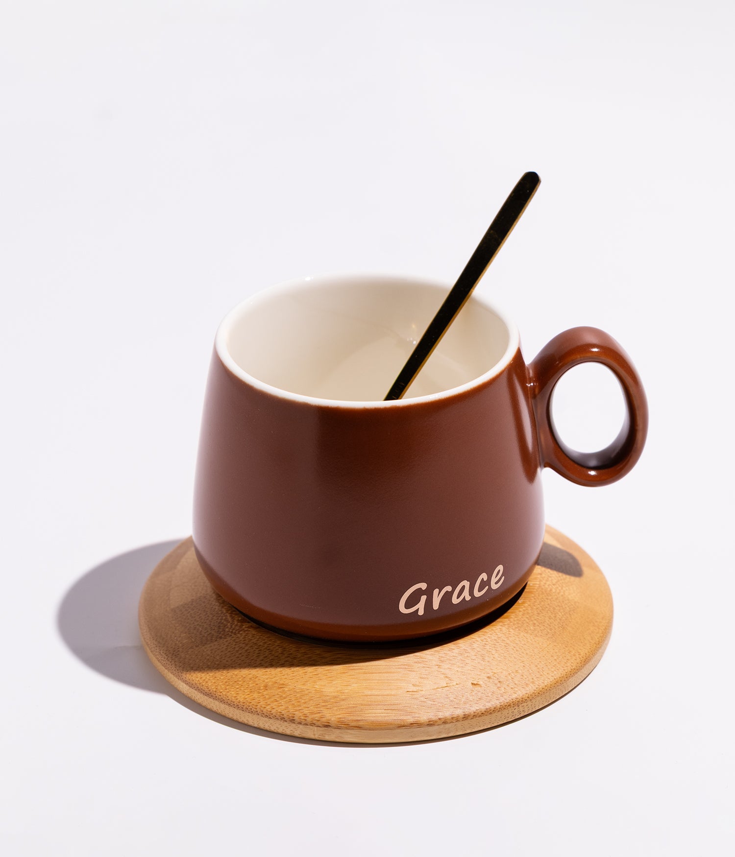فنجان سيراميك بعبارة «GRACE» مع قاعدة خشبية دائرية وملعقة بلون بني