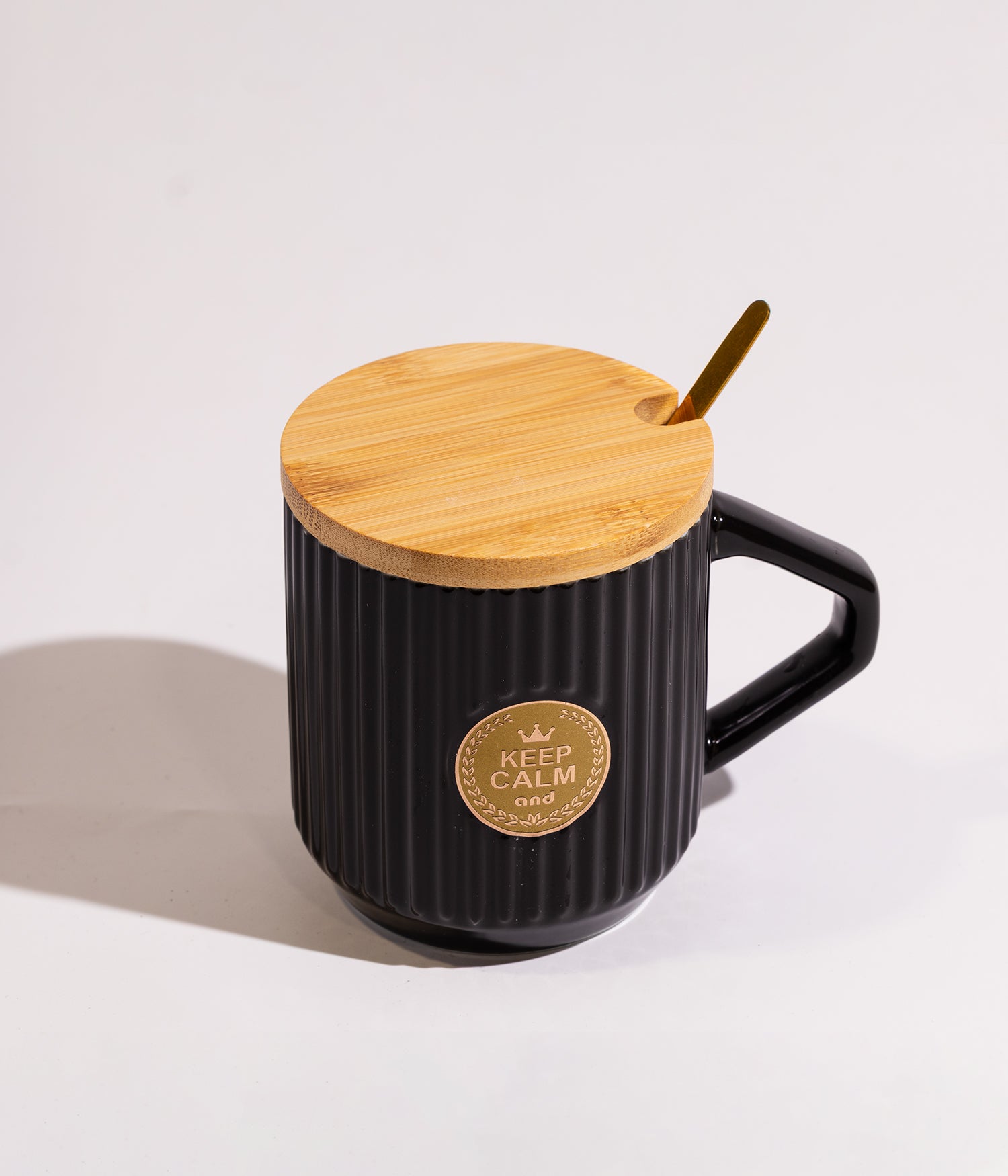 كوب سيراميك بتصميم مموج مع دائرة ذهبية ملكية في الوسط، مع غطاء خشبي وملعقة باللون الأسود