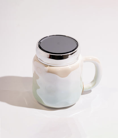 كوب سيراميك بتصميم هندسي مموج مع تدرج لوني فاتح، وغطاء محكم الإغلاق لحفظ الحرارة باللون الأزرق المخضر