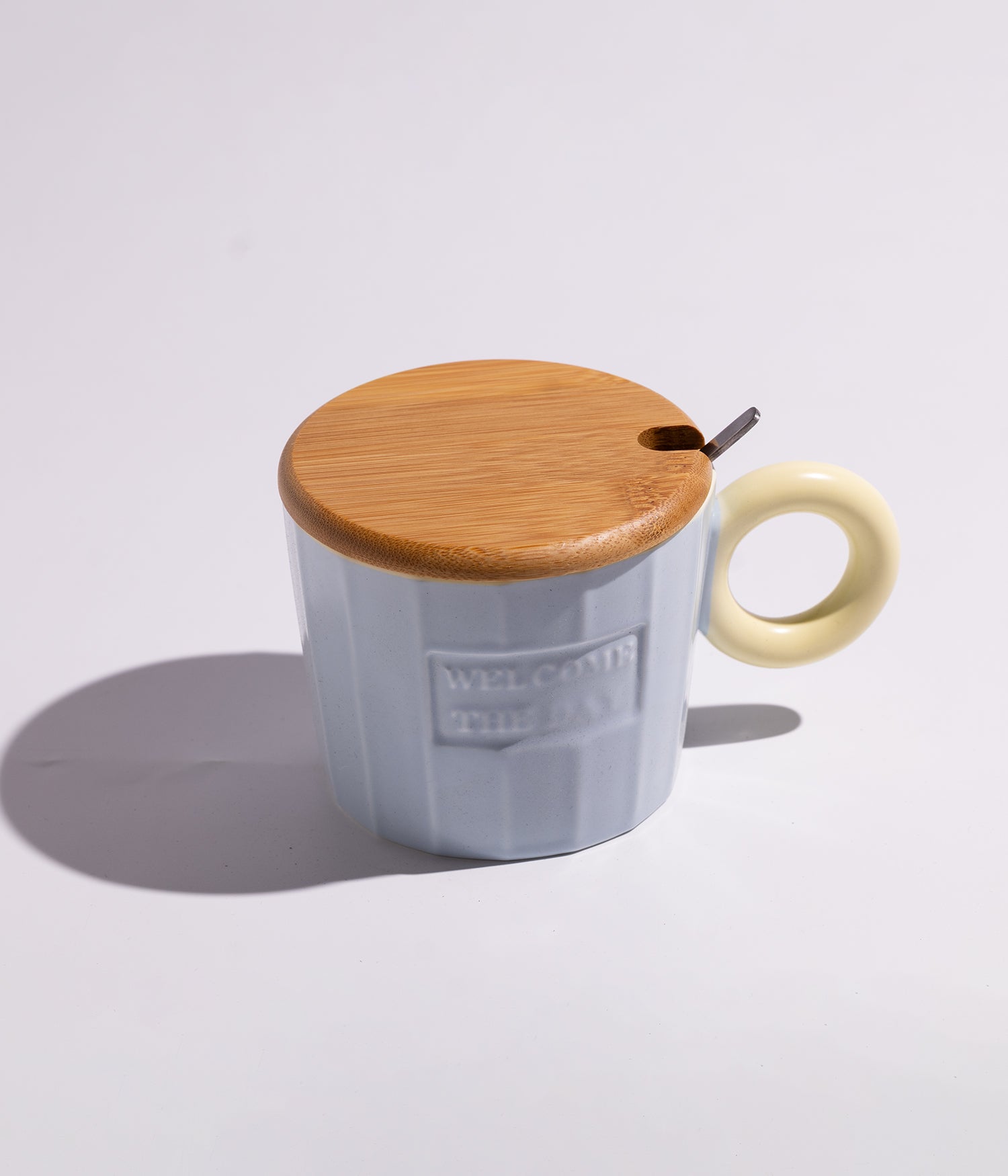 كوب سيراميك بعبارة «WELCOME THE DAY» مع غطاء خشبي وملعقة بلون أزرق