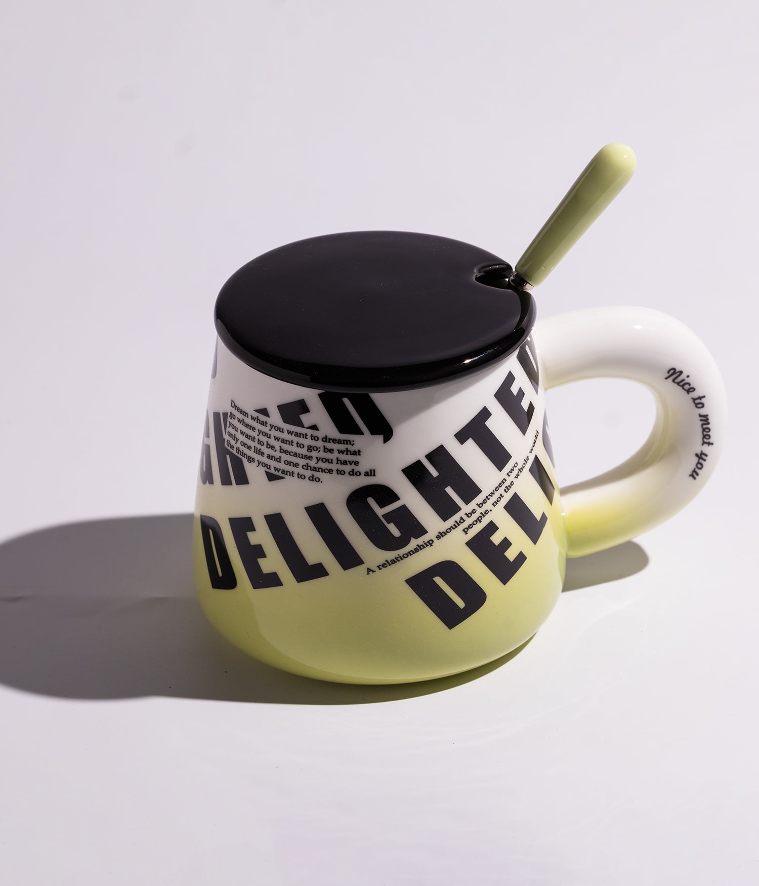 كوب سيراميك بتدرجات لونية صفراء مع عبارات لطيفة، مزوّد بغطاء أسود وملعقة