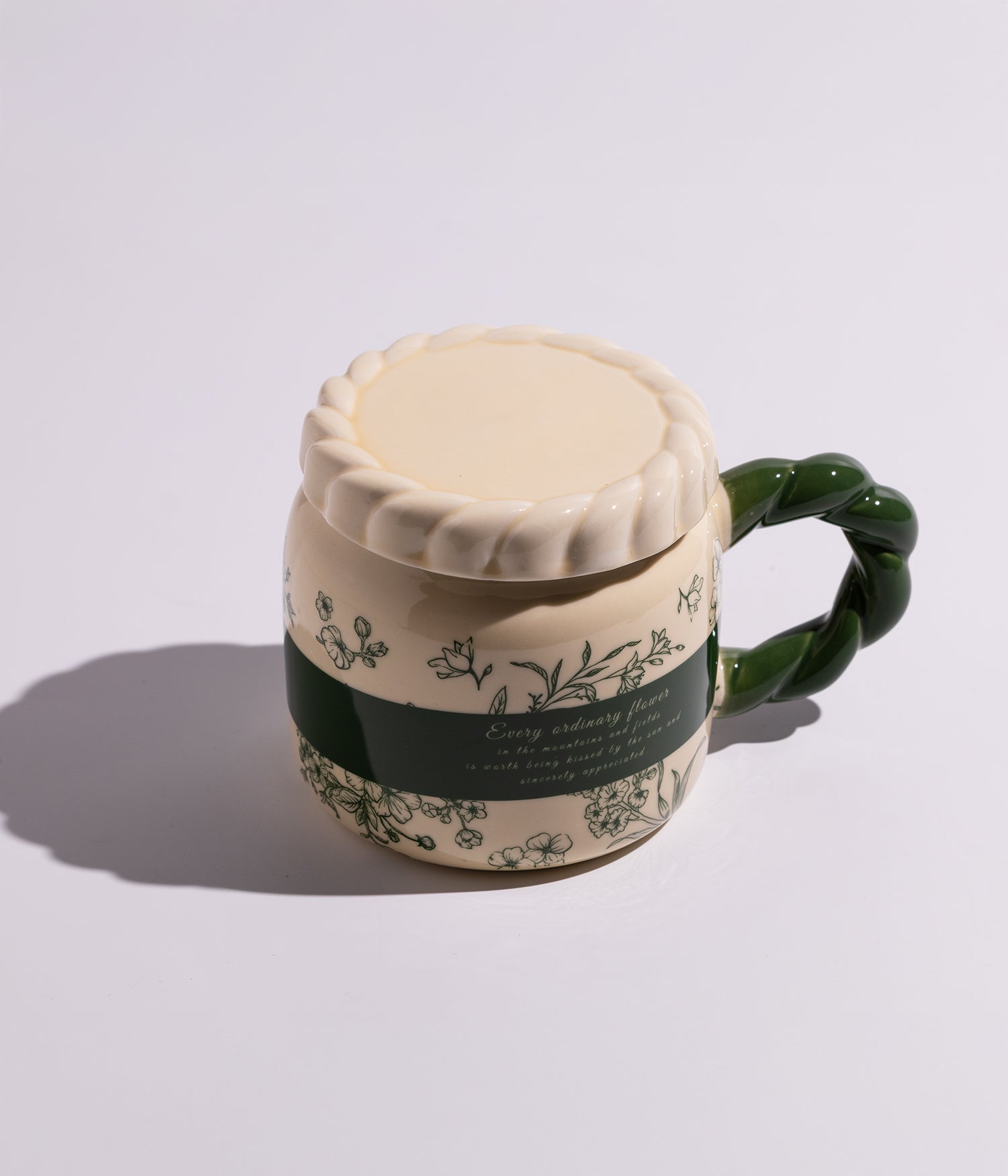 كوب مصنوع من السيراميك مزين بورود ملونة، مزود بمقبض أخضر وغطاء محكم الإغلاق، مناسب للاستخدام اليومي مع القهوة أو الشاي