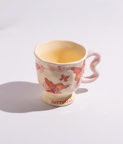 فنجان قهوة بمقبض مموج فريد مع فراشات ملونة بنقوش حمراء