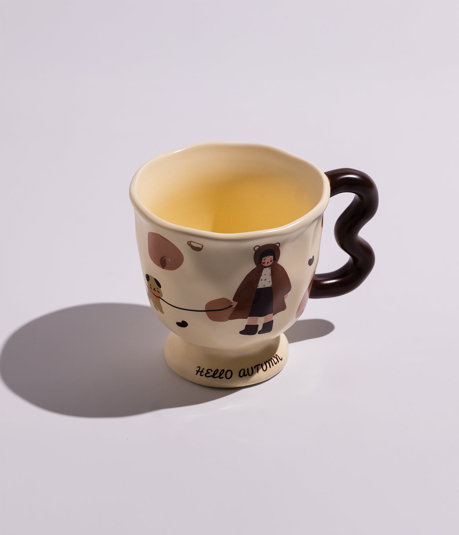 كوب سيراميكي بألوان كريمية مزين بشخصيات كرتونية لطيفة، مزود بمقبض مموج، مناسب للاستخدام اليومي مع القهوة أو الشاي