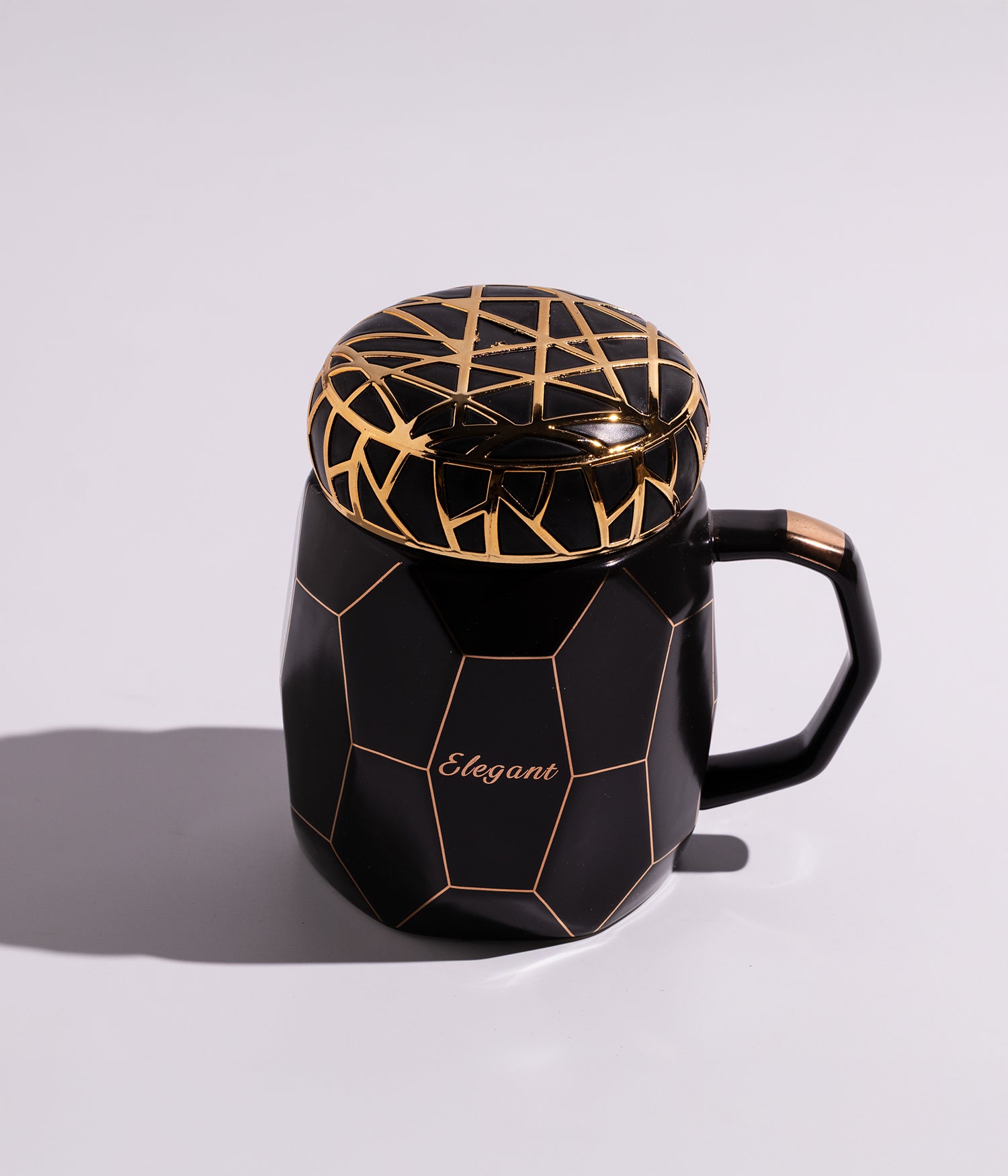 كوب من السيراميك باللون الأسود الداكن مزين بخطوط ذهبية أنيقة على الغطاء، مثالي لتقديم المشروبات الساخنة
