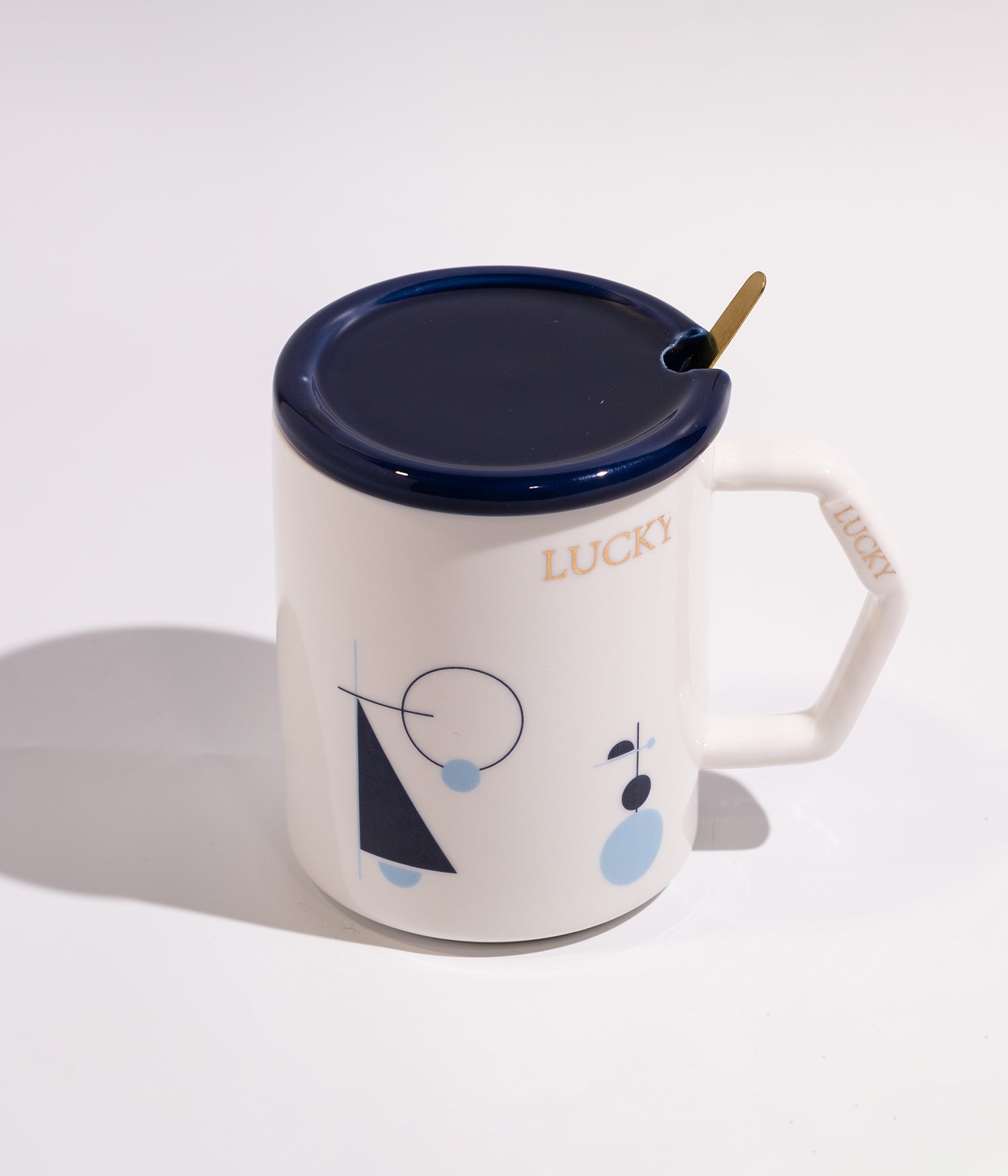 كوب سيراميك أنيق برسومات هندسية وعبارة «محظوظ» مع غطاء وملعقة بلون أبيض