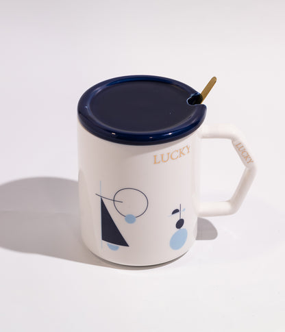 كوب سيراميك أنيق برسومات هندسية وعبارة «محظوظ» مع غطاء وملعقة بلون أبيض