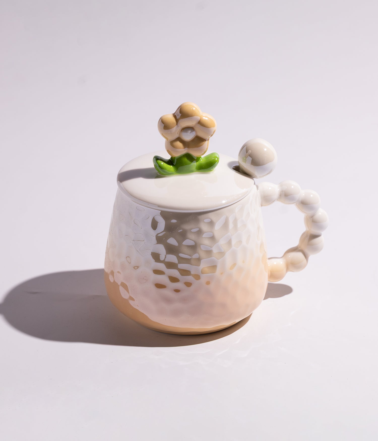 كوب مصنوع من السيراميك بتدرج لوني باللون البرتقالي، مزود بتصميم مجسم وردة على الغطاء وملعقة مرفقة، مناسب للاستخدام اليومي مع القهوة أو الشاي