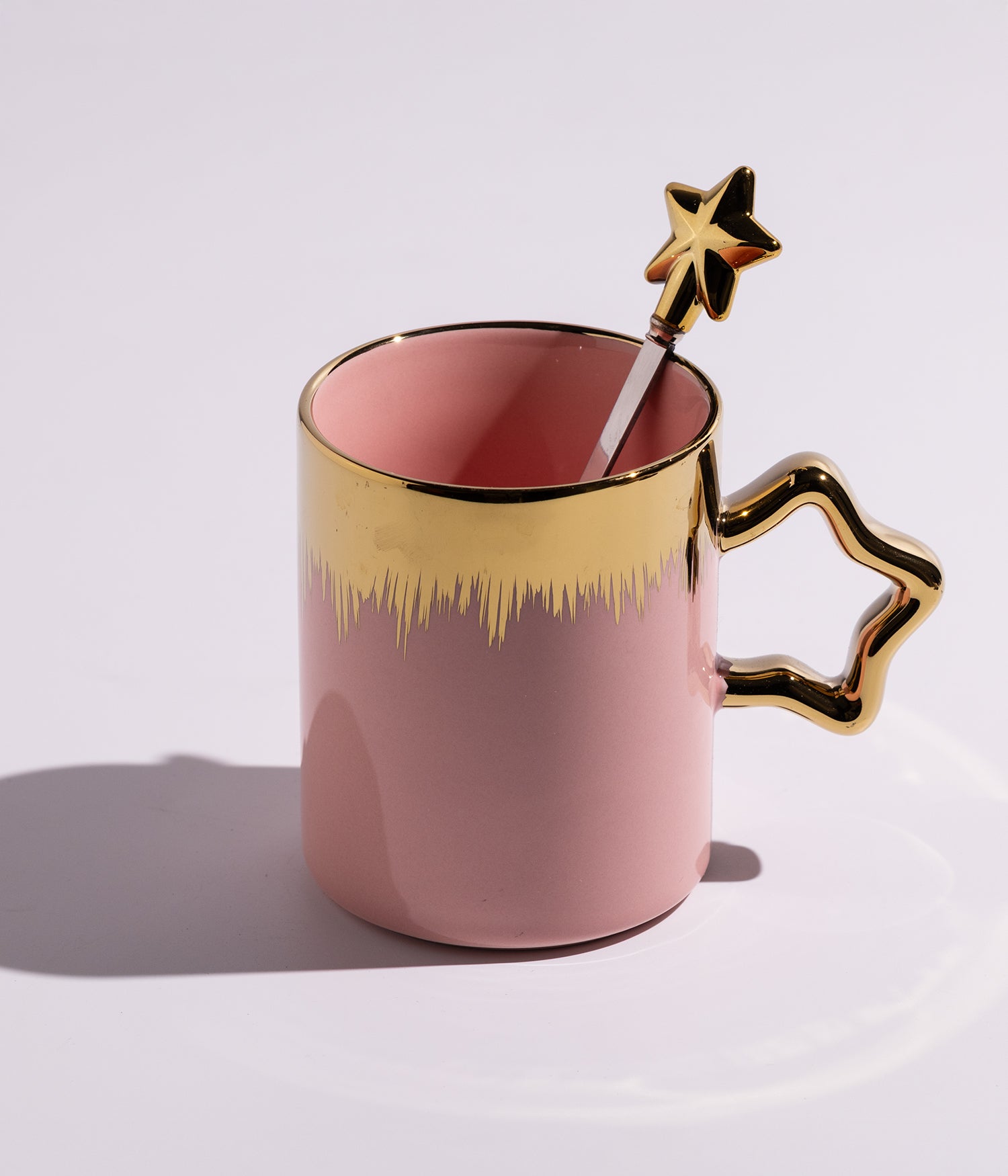 كوب مصنوع من السيراميك باللون الوردي مع خطوط سنابل ذهبية، يأتي مع ملعقة بتصميم نجمة، مناسب للقهوة أو الشاي