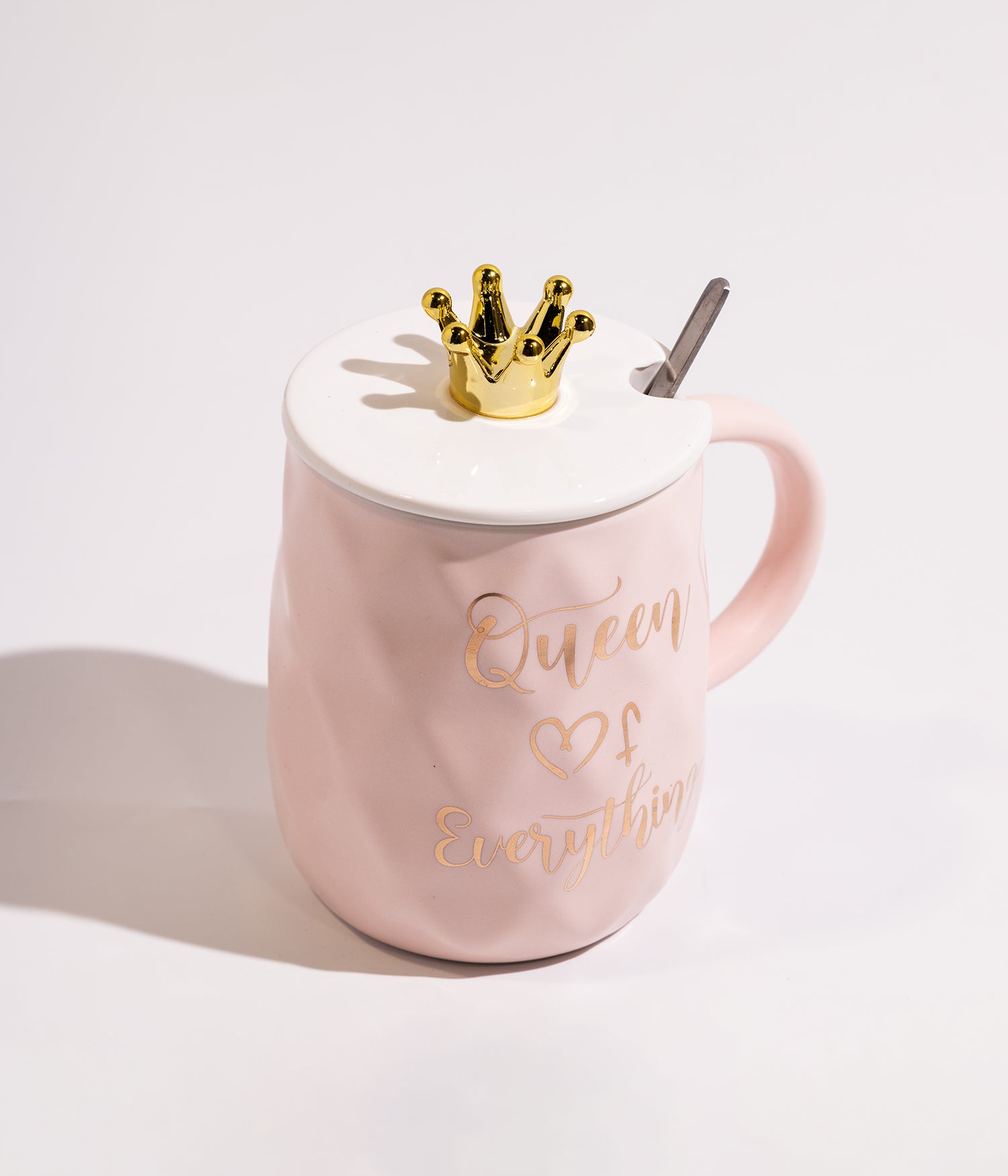 كوب قهوة سيراميكي وردي يحمل عبارة Queen، يأتي مع غطاء بتصميم تاج وملعقة مرفقة، ملائم للاستخدام اليومي في المنزل أو المكتب