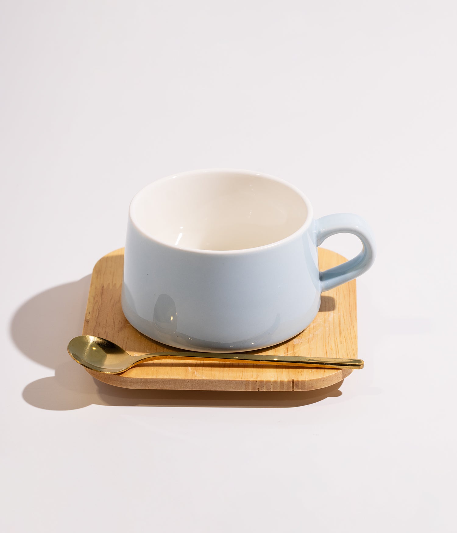 فنجان سيراميك سادة ازرق مع قاعدة خشبية وملعقة