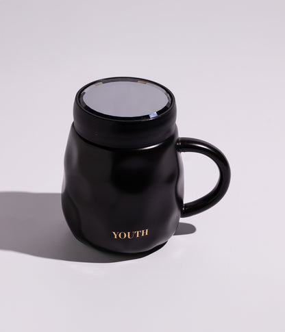 كوب قهوة سيراميك بتصميم عملي مع غطاء حافظ للحرارة، مزين بكلمة YOUTH باللون الذهبي، باللون الأسود
