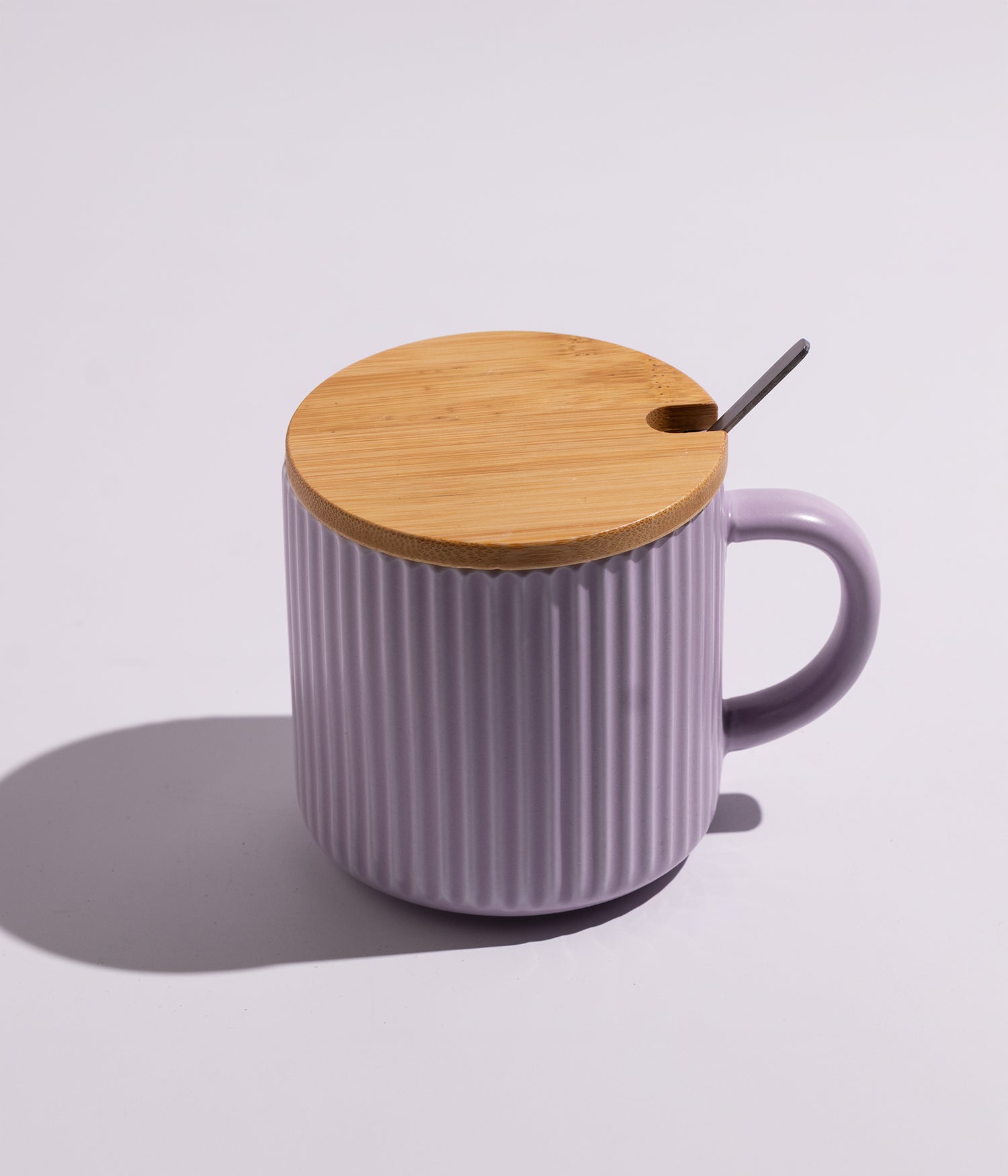 كوب مصنوع من السيراميك باللون البنفسجي مزين بخطوط أنيقة، مزود بغطاء خشبي وملعقة، مناسب للاستخدام اليومي مع القهوة أو الشاي