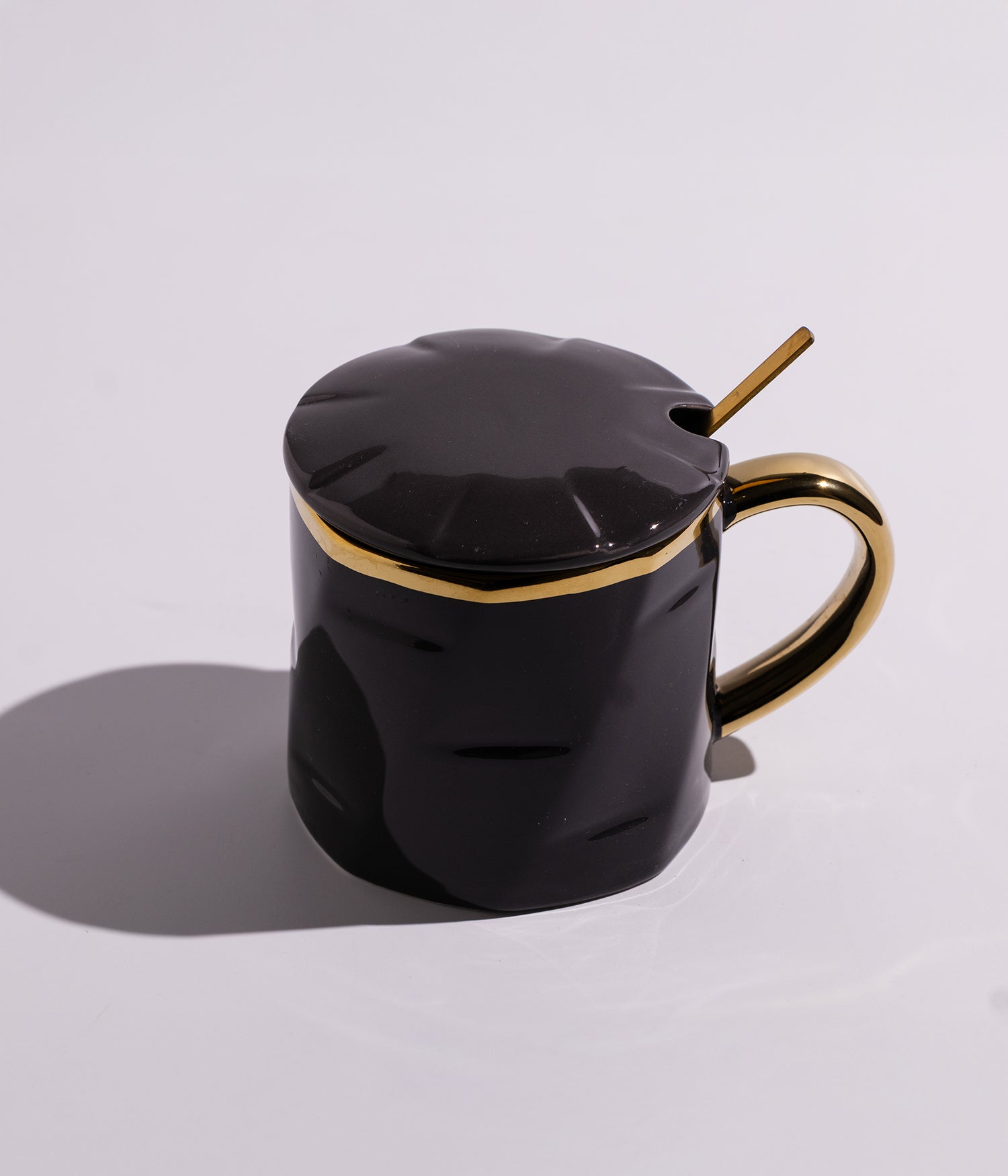 كوب سيراميك بتصميم سادة مزين بخطوط ذهبية مع مقبض ذهبي، مزود بغطاء وملعقة، باللون الأسود