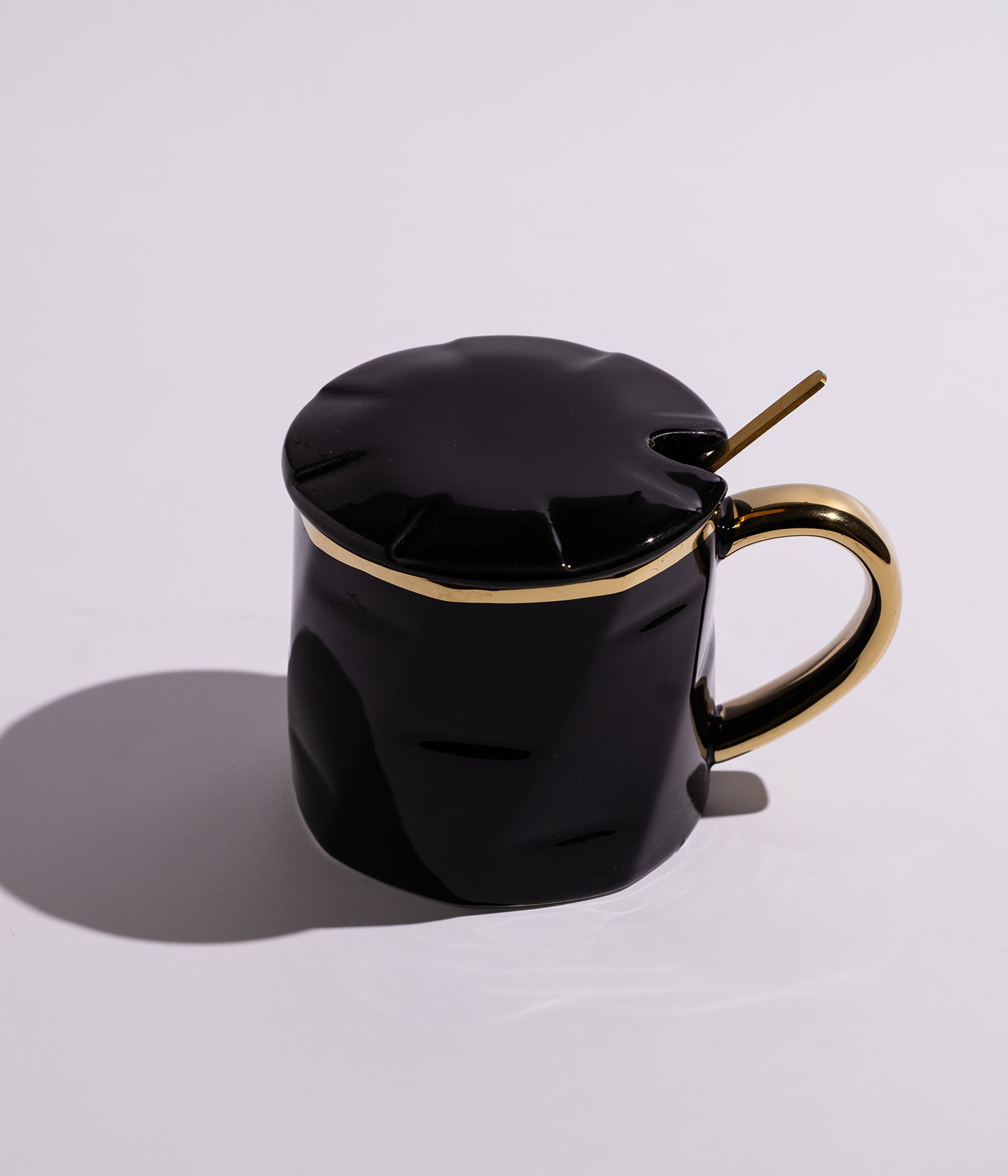 كوب سيراميك بتصميم سادة مزين بخطوط ذهبية مع مقبض ذهبي، مزود بغطاء وملعقة، باللون الأسود