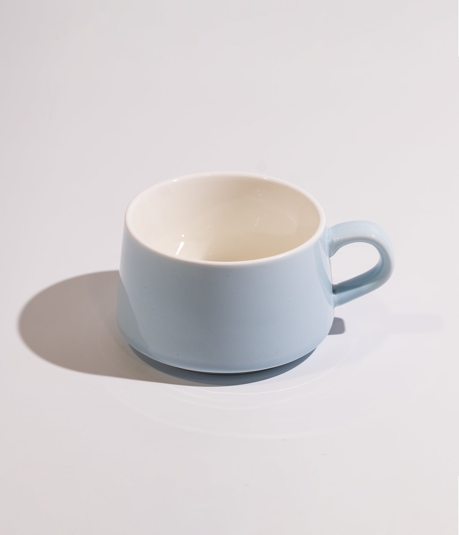 Plain and modern ceramic coffee cup with wooden base and spoon