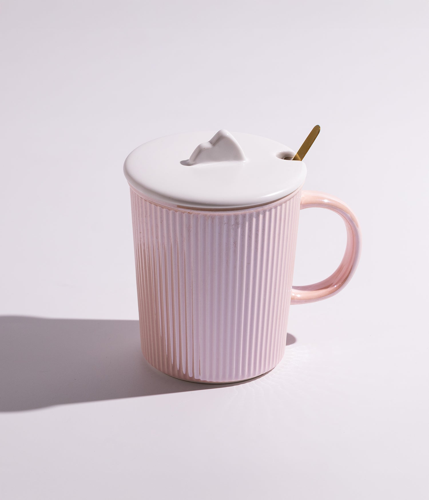 كوب سيراميك مخطط أنيق مع غطاء أبيض وملعقة ذهبية