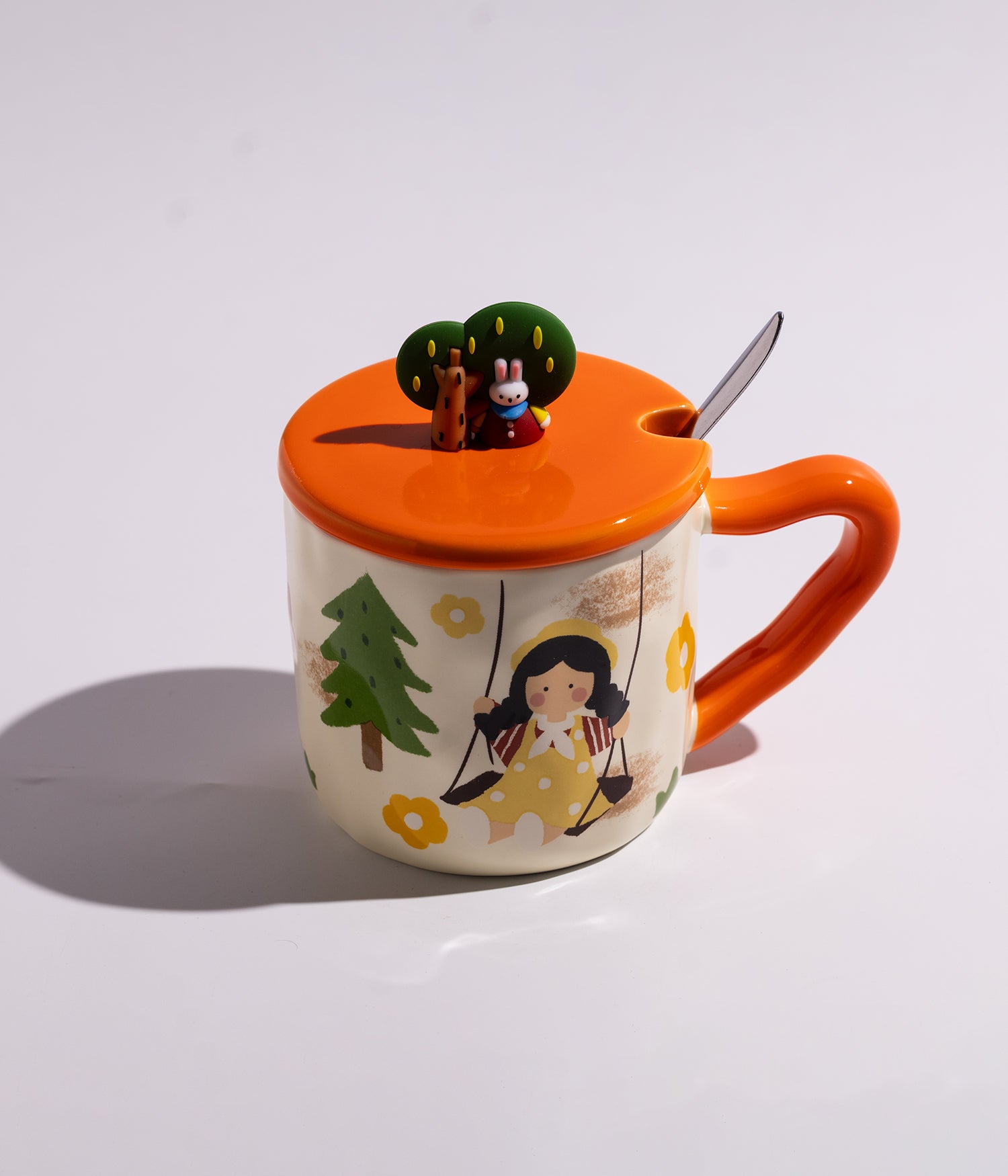 كوب مصنوع من السيراميك باللون الأبيض مع تصميم الفتاة المرحة، مزود بغطاء برتقالي بديكور شجرة وملعقة، مناسب للاستخدام اليومي مع القهوة أو الشاي