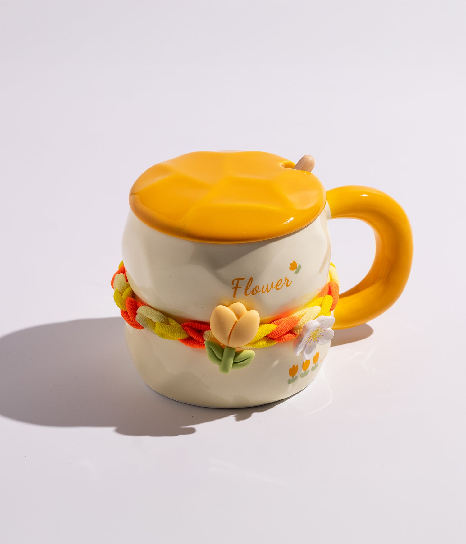 كوب سيراميكي باللون الأصفر مزين بوردة في وسط الكوب، مزود بغطاء وملعقة، مناسب للاستخدام اليومي مع القهوة أو الشاي